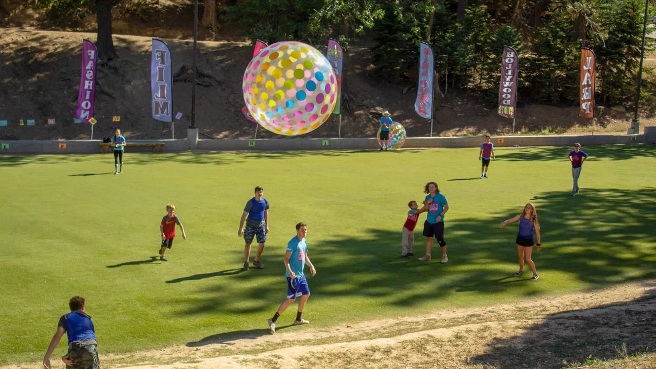 Campers on field playing with giant inflatable ball