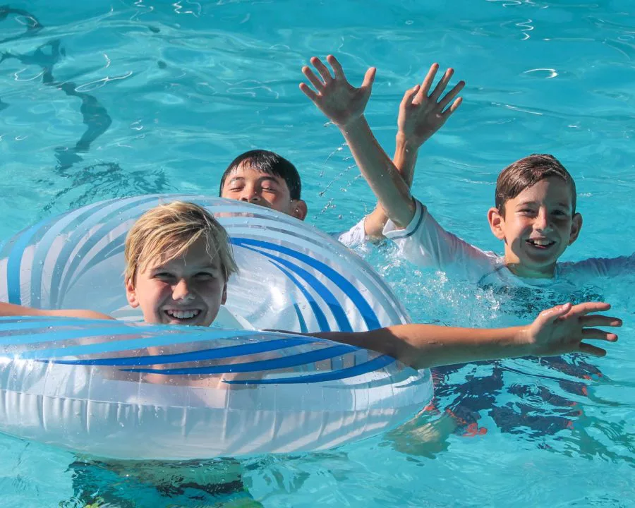 Three boys in swimming pool with tubes