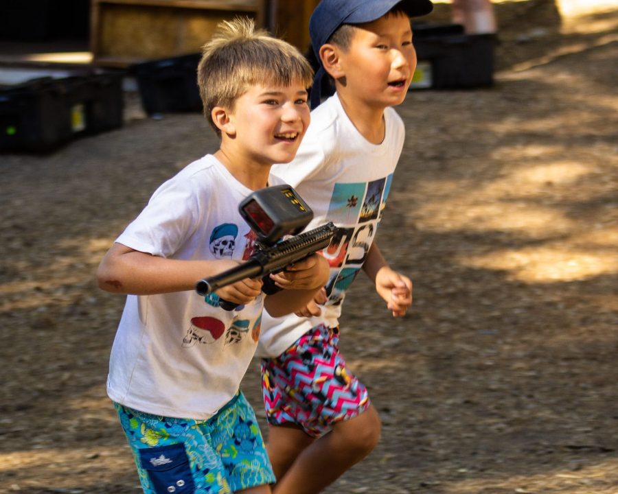 Two boys running while playing laser tag