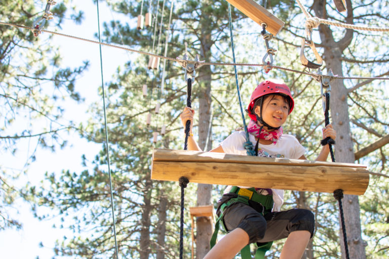 a girl traversing a ropes course