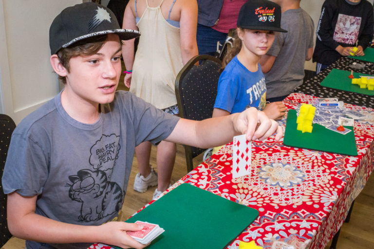 a boy showing off a magic card trick