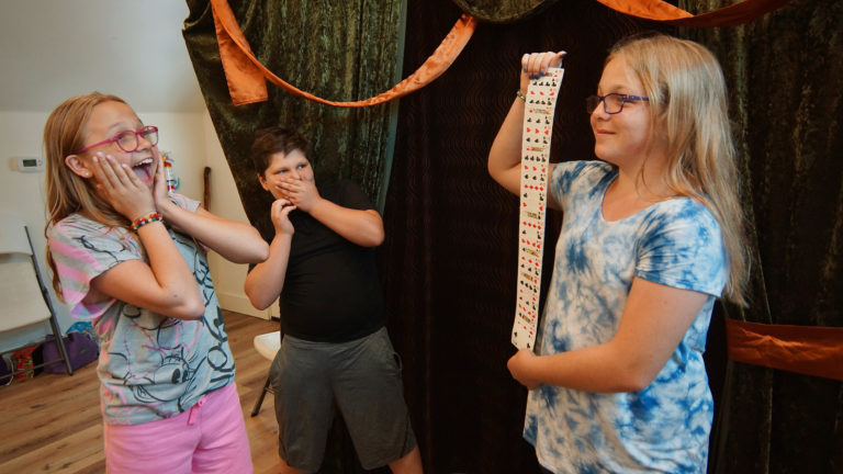 a girl showing off a magic card trick