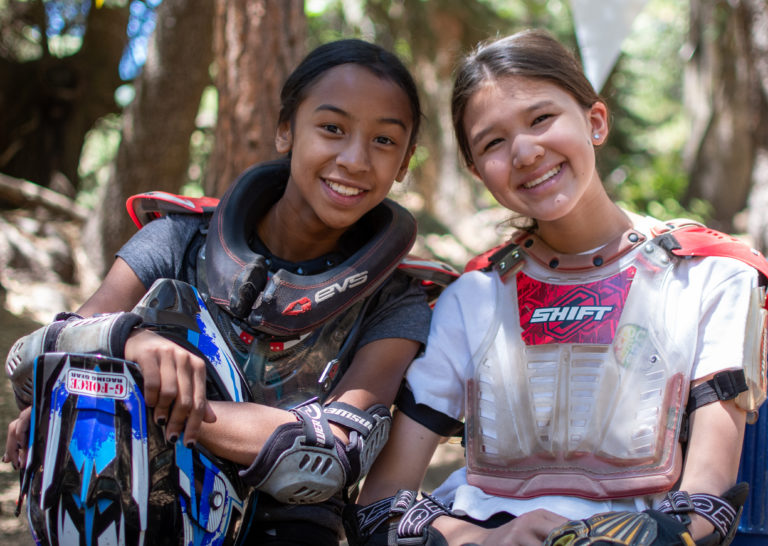 two girls smiling on a motorsport track