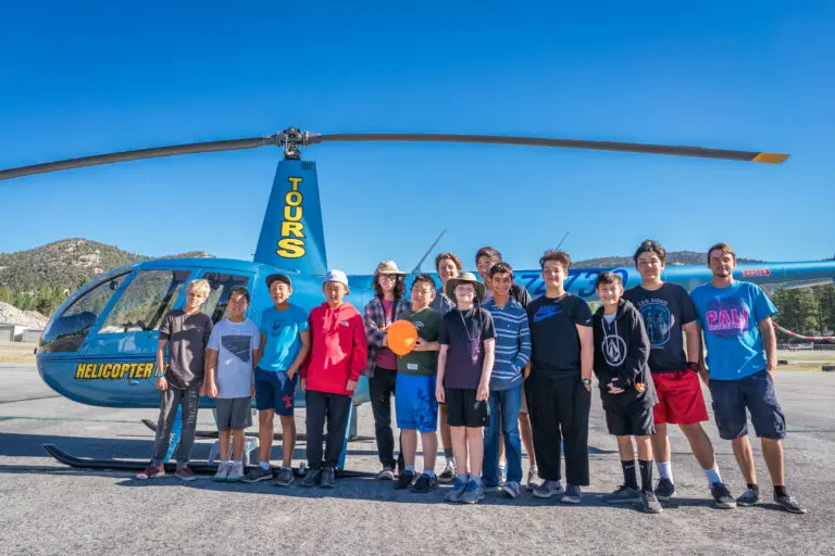 kids standing in front of a helicopter