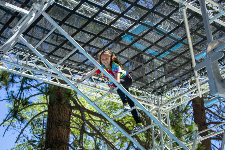 a girl traversing a metal ladder