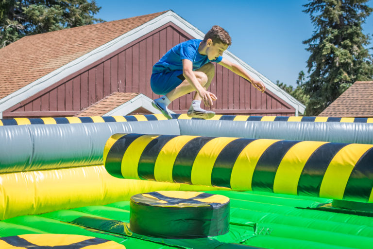 a boy jumping over a moving obstacle