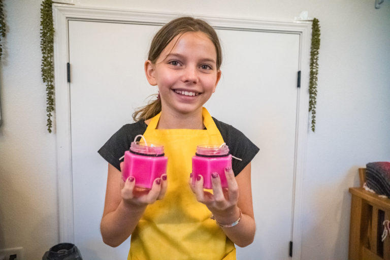 a girl holding two pink candles