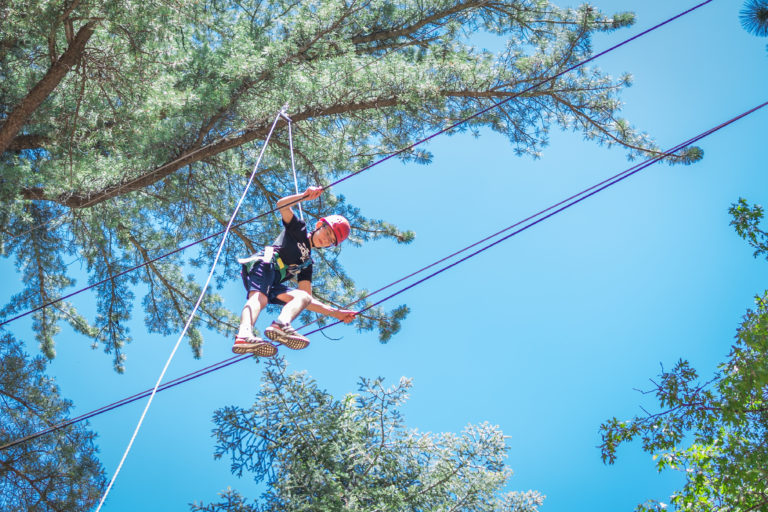 a boy walking on a ropes course