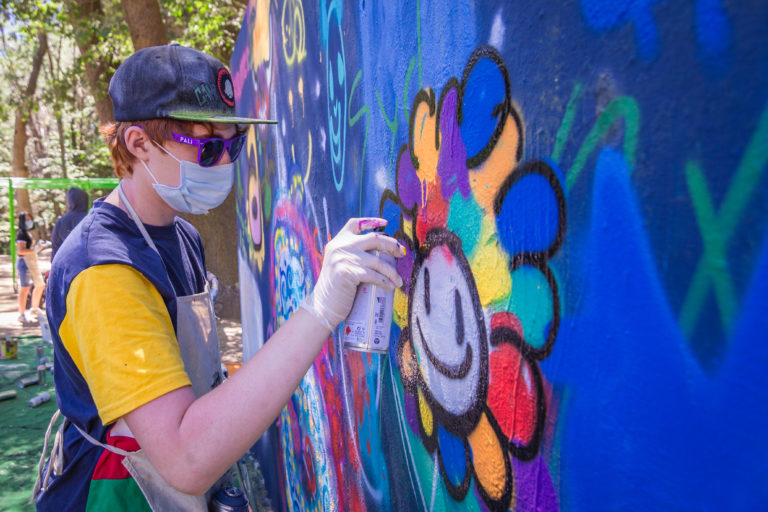 a boy spray painting a wall