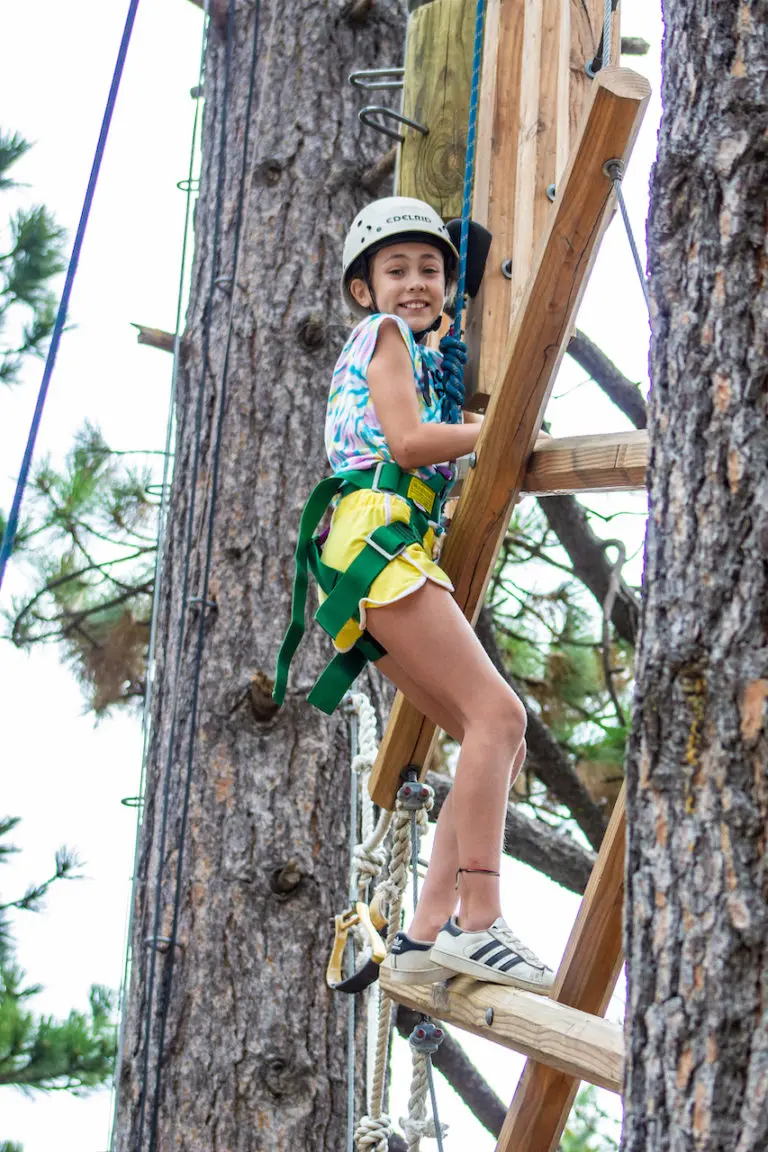 girl tree climbing at summer camp