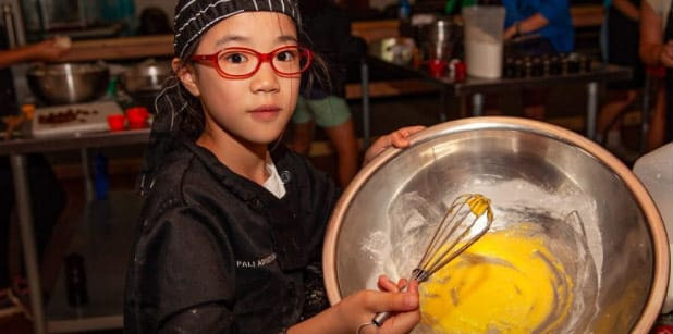 Camper whisking batter in the camp kitchen