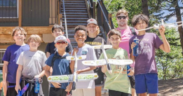 Campers holding model airplanes they built